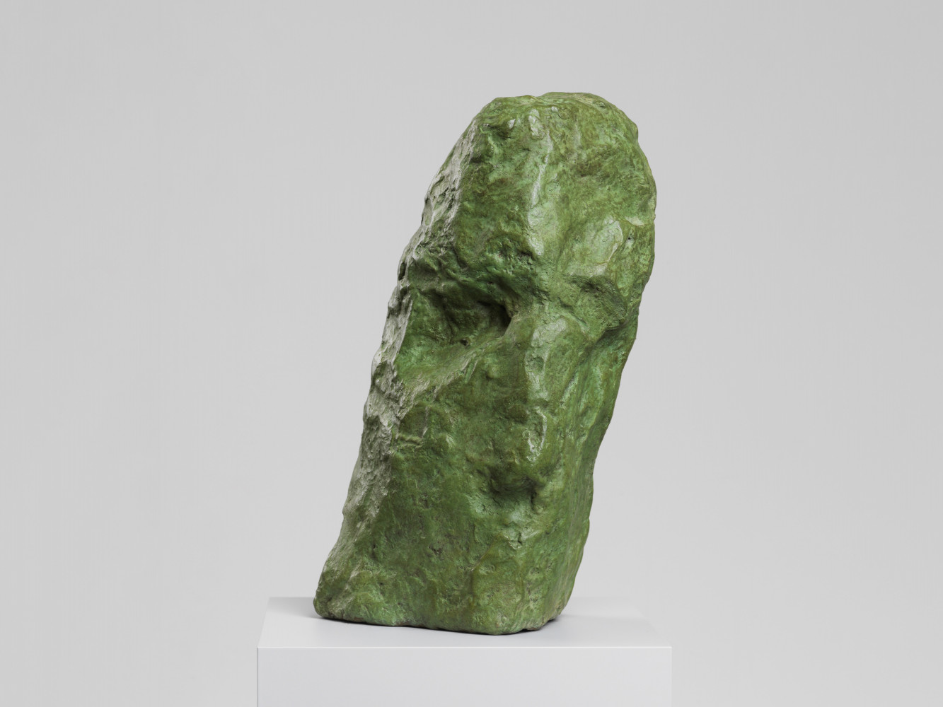 A sculpture in the form of a head in patianted bronze (green)