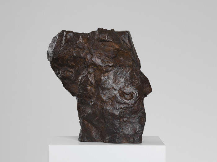 a sculpture made from bronze depicting a mask